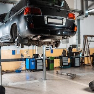 modern-black-car-raised-on-car-lift-in-workshop-2023-11-27-05-32-58-utc (1)